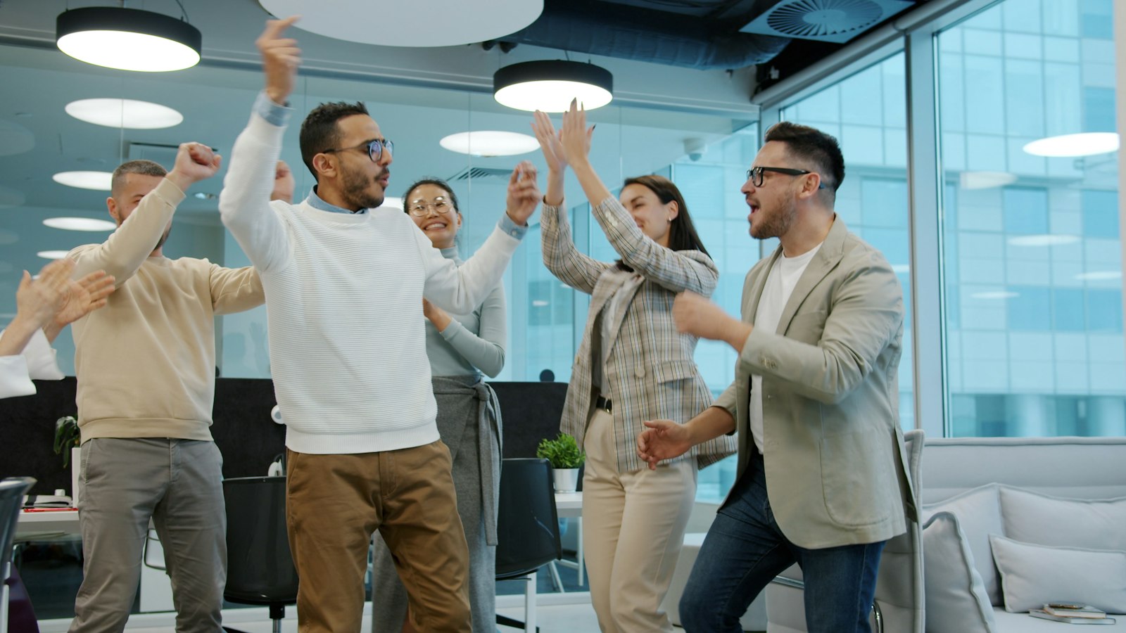Colleagues celebrating a team win in the office
