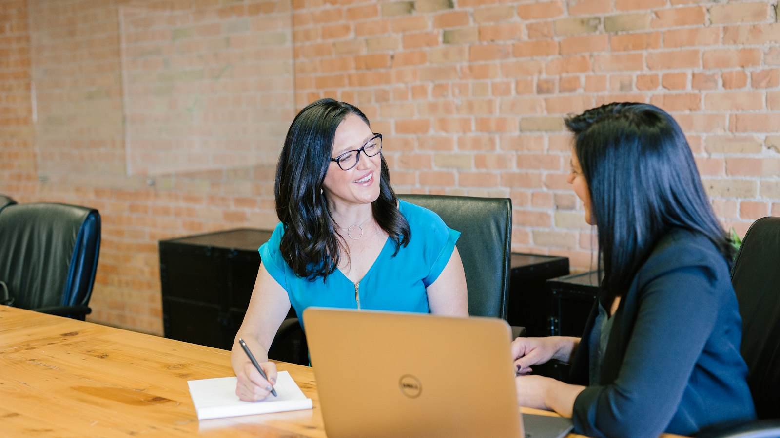 Manager and employee in a one-on-one conversation at a meeting table